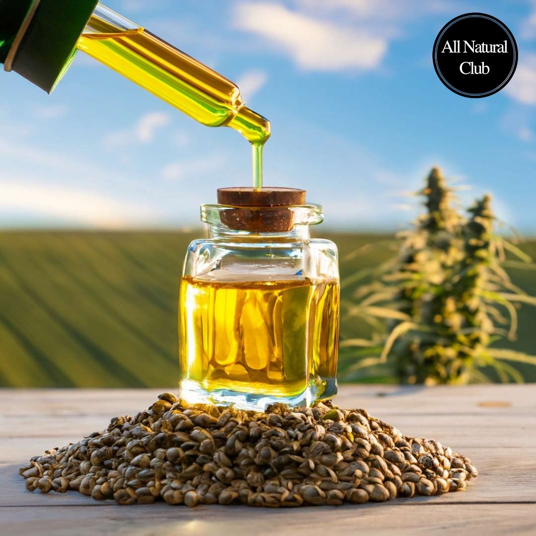 Image of hemp seed oil being poured into small ornate glass jars with hemp seeds around and behind the table. With beautiful sky and hemp plants growing in the background.